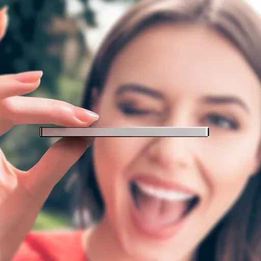 Woman holding a thin device sideways with her face in the background smiling and winking